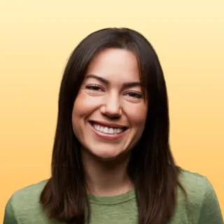 a woman with long hair smiling at the camera
