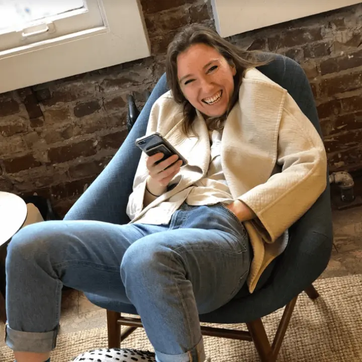 a woman sitting in a chair holding a cell phone