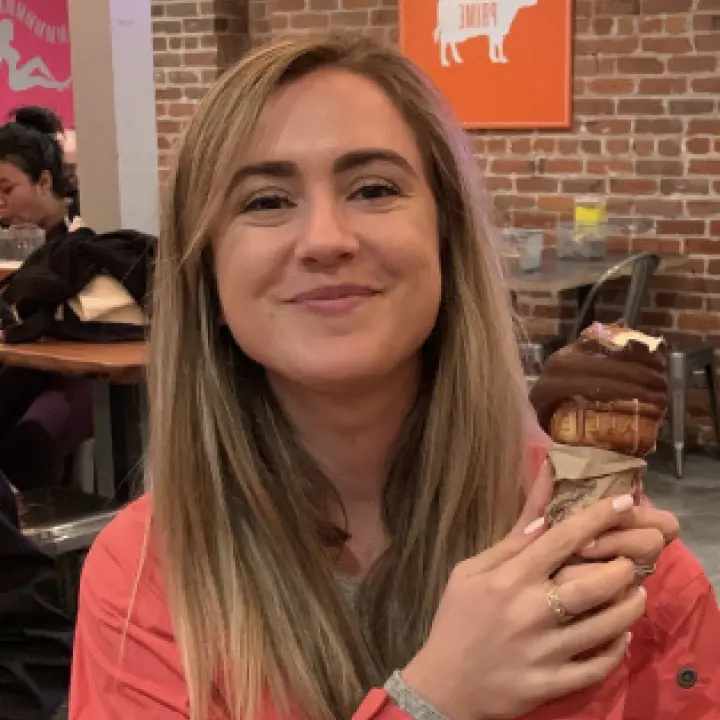 a woman holding a piece of cake in her hands